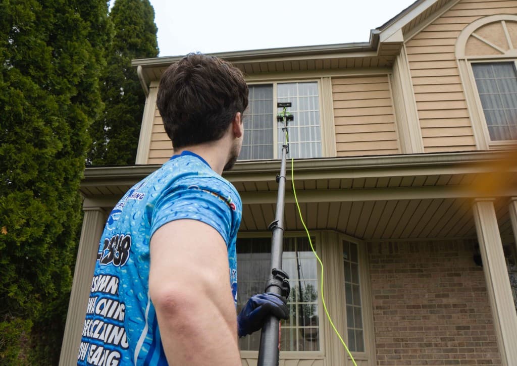 A to Z Power Washing technician cleaning second-story windows with a water-fed pole